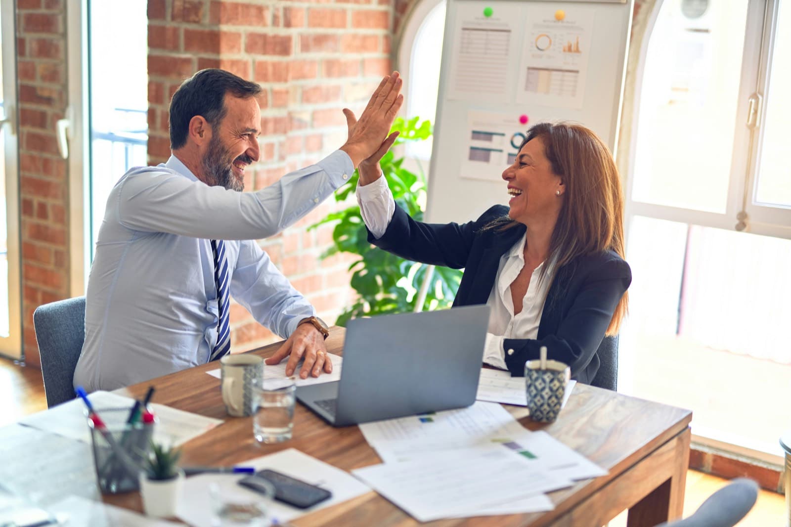 Personas trabajando juntas y felices en un encuentro Entre Nós